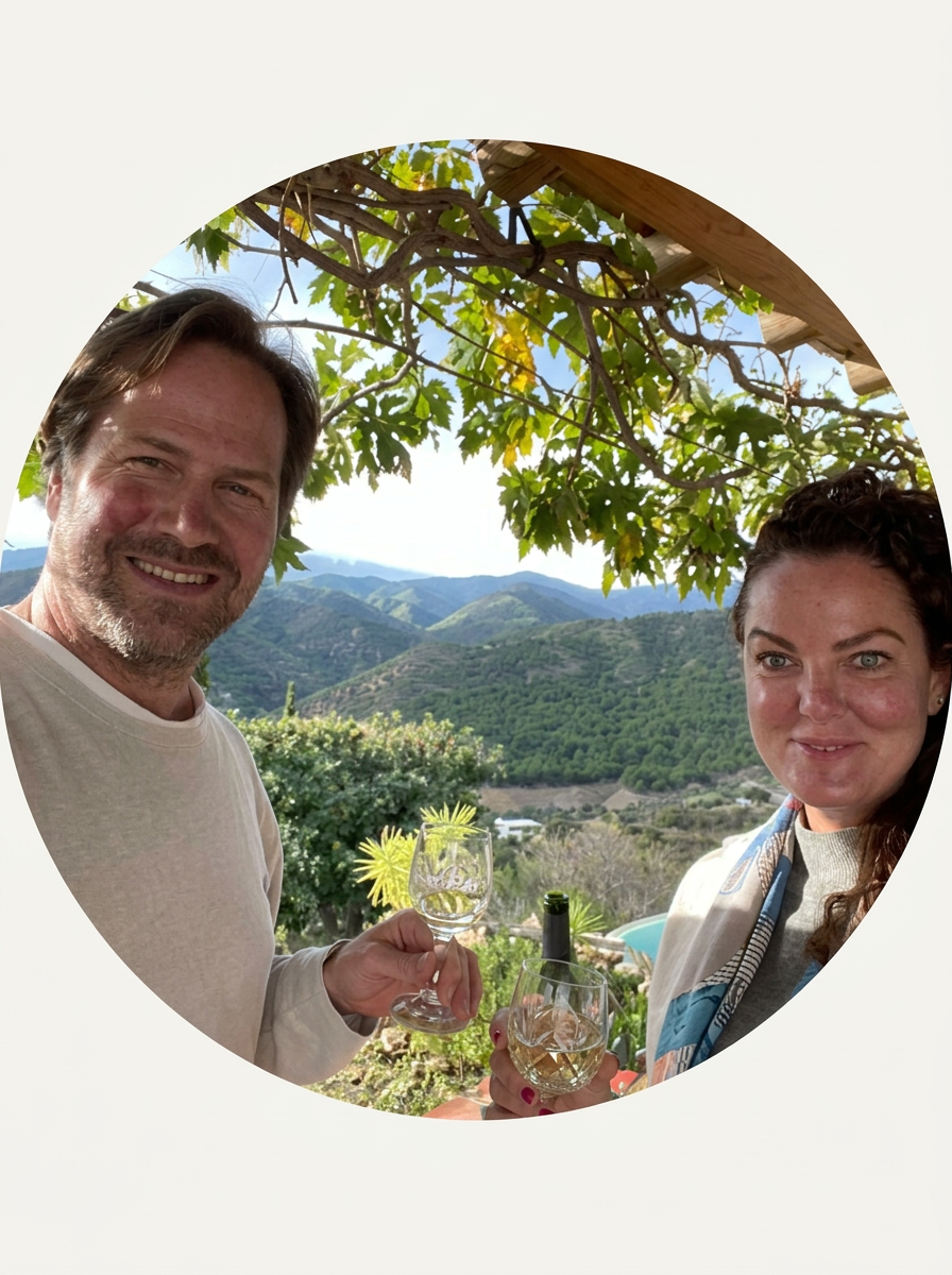 Elin & Kenneth toasting white wine on a terrace overlooking the mountains
